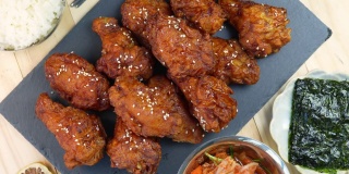 韩式炸鸡配辣酱传统的韩式食物，炸鸡配米饭和泡菜放在木桌上。
