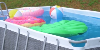 在夏天的暴雨中，后院的小游泳池里装满了五颜六色的漂浮物。