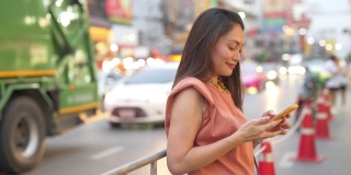 在泰国曼谷的夜市，一名4K亚洲妇女在使用智能手机旅行