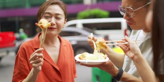 4K群亚洲人朋友一起走在唐人街一起吃街头小吃