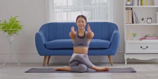平静的亚洲女性穿着运动服，伸展肌肉，热身呼吸和冥想，在家做瑜伽，健康的女性做瑜伽，感觉如此舒适和放松，健康瑜伽保健概念