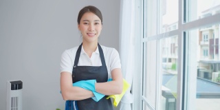 亚洲年轻清洁服务女工在房子工作的肖像。美丽的女孩主妇管家清洁工交叉手臂微笑，在做家务或家务后看着相机。