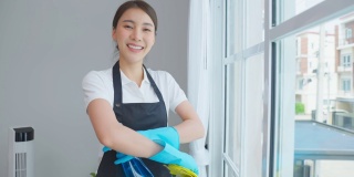 亚洲年轻清洁服务女工在房子工作的肖像。美丽的女孩主妇管家清洁工交叉手臂微笑，在做家务或家务后看着相机。