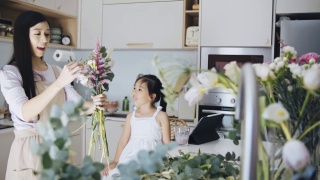 亚洲女性花商与她的女儿谈话，而工作插花。早上做小生意的日常工作视频素材模板下载