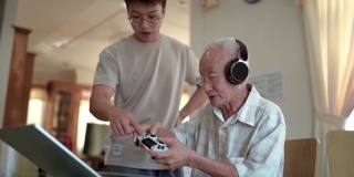 亚洲华人爷爷玩网络游戏在家教孙子。