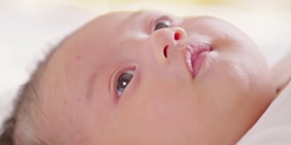 母亲用棉垫清洁新生儿的眼睛。新生儿看着妈妈用爱擦干她的身体。新生儿护理概念