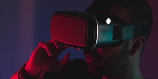 年轻人戴着VR眼镜，在彩色霓虹灯下与虚拟现实互动，未来科技，教育视频游戏