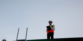 工程师们正站着检查在工厂屋顶工作的规格，高空工作，高空工作的风险。