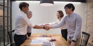一群多元化的业务伙伴在成功达成业务协议后高兴地握手