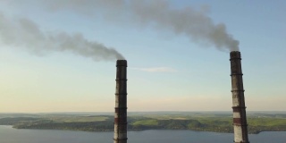 从空中俯瞰高耸的烟囱管和灰色的烟从燃煤电厂。用化石燃料发电。
