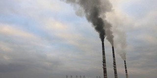 从空中俯瞰燃煤电厂高高的管道，黑烟在污染的大气中向上移动