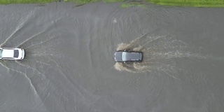 城市交通鸟瞰图，汽车行驶在暴雨后被淹没的街道上。道路排水系统的问题