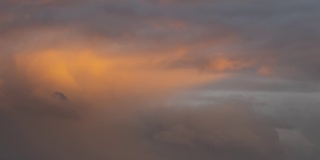 日落时分，深黄的天空上快速移动的暴风云。