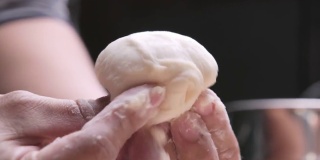 女厨师手做中国饺子或蒸馒头蔬菜和碎猪肉。面团已准备好成形。包子的制作过程。