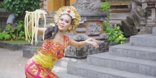 迷人的巴厘岛舞女拿着鲜花表演