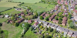 航拍的英国西约克郡韦克菲尔德奥塞特村中心的视频显示，在一个阳光明媚的夏日里，从空中俯瞰英国的住宅、道路和街道。