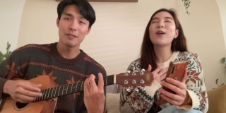 年轻夫妇在客厅里一起唱歌玩得很开心