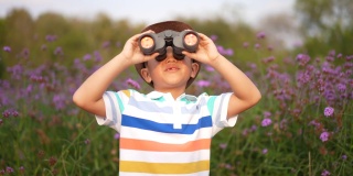 亚洲孩子用望远镜和放大镜在公园和森林里学习户外运动