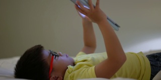 亚洲男孩在数码平板电脑上玩社交媒体。成瘾的概念