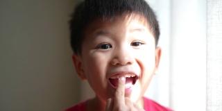 亚洲男孩展示他的乳牙和间隙牙。
