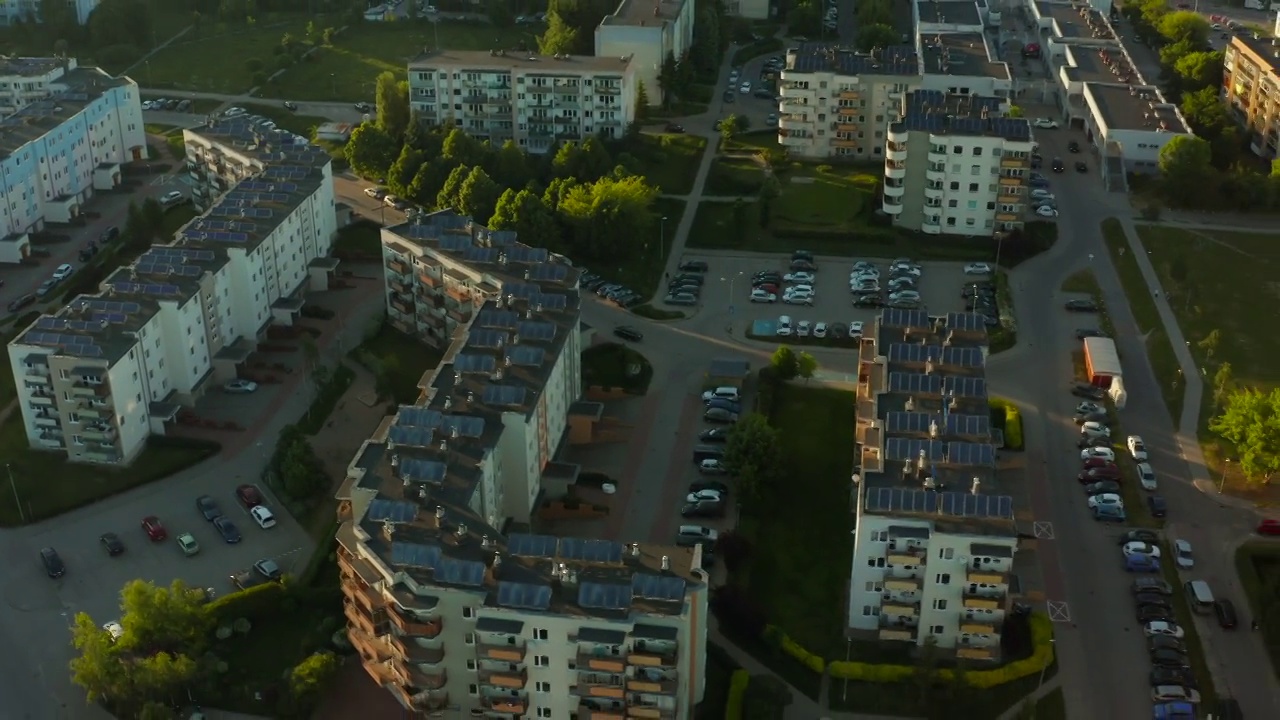 从上到下的鸟瞰图光伏太阳能电池板安装在住宅建筑的平屋顶，在一个欧洲城镇的现代地区。现代可再生电力系统