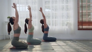 一群通过做瑜伽来学习或锻炼的亚洲妇女。视频素材模板下载