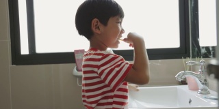 亚洲男孩刷牙是为了防止蛀牙。孩子们吃完饭后要注意口腔卫生。