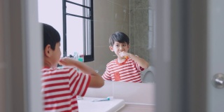 亚洲男孩刷牙是为了防止蛀牙。孩子们吃完饭后要注意口腔卫生。
