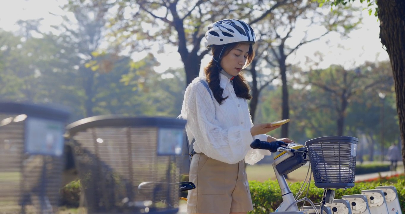 亚洲女商人在市中心租用共享自行车上班或上班