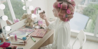 小女孩在镜子前化妆。