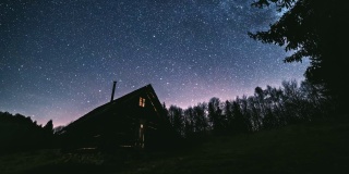 童话般的夜空，在原始森林的小木屋上，银河星系的数百万颗星星。天文学
