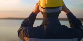 日落时分戴着防护头盔的男性工程师。