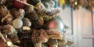 五颜六色的圣诞树上挂着被雪压碎的新年球美丽的背景为节日的圣诞贺卡