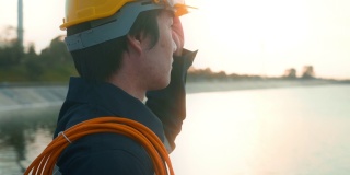 日落时分戴着防护头盔的男性工程师。