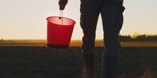 日落时分，农夫提着水桶穿过田野