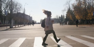快乐的女学生背着书包在城市里