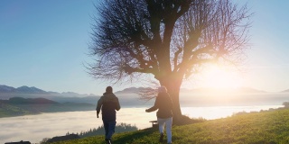 男人和女人夫妇一起在户外散步在自然的树木景观爬山看日落全景
