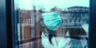 一名妇女戴上医用口罩，看着窗外的街道，车窗外有汽车驶过