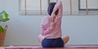 平静的亚洲女性在休闲伸展肌肉热身呼吸和冥想与瑜伽在家，健康的女性做瑜伽感觉如此舒适和放松，健康瑜伽保健概念