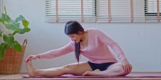 平静的亚洲女性在休闲伸展肌肉热身呼吸和冥想与瑜伽在家，健康的女性做瑜伽感觉如此舒适和放松，健康瑜伽保健概念