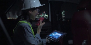 身着制服的女性主管在能源行业工作，晚上开车检查石化工厂。