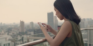 亚洲女性使用智能手机与朋友聊天。
