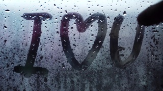 在磨砂玻璃上用英文手写“我爱你”。视频素材模板下载