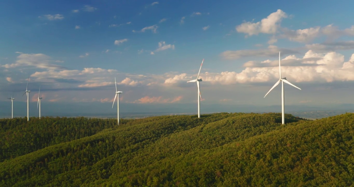 航拍风力发电机旋转的力量，并产生可再生能源的绿色生态方式，以太阳照耀地球。