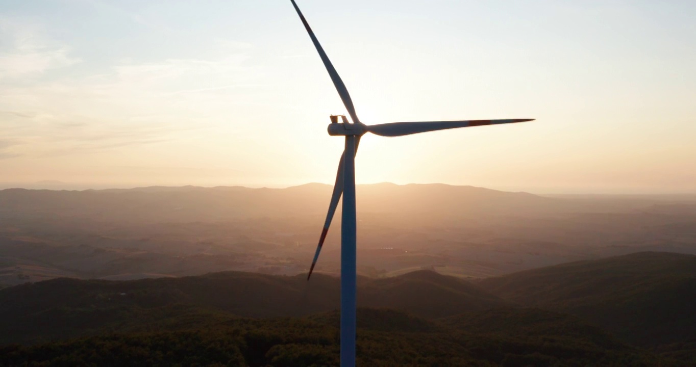 航拍风力发电机旋转的力量，并产生可再生能源的绿色生态方式，以太阳照耀地球。