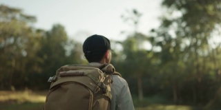 男子在假日里背着背包在树林里徒步旅行。
