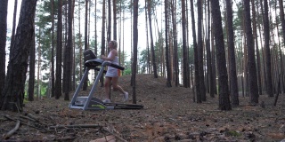 一名年轻女子在森林里的跑步机上跑步。多莉拍摄
