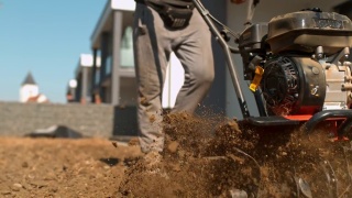超级SLO MO园丁用耕耘机在草坪上犁地视频素材模板下载