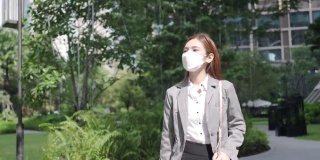 在泰国曼谷，一名穿着套装的亚洲女商人在“污染城市”上班，她戴着防护口罩，以防止PM2.5尘埃、雾霾、空气污染和新冠肺炎