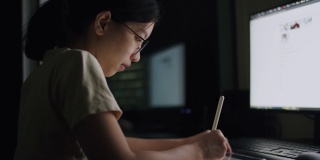 一名年轻女性晚上在家庭办公室用平板电脑写文章，滚动新闻推送，为她的工作计划搜索在线信息数据。